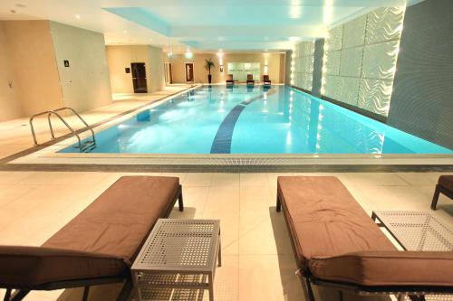 a large swimming pool in a building with benches in it at Crowne Plaza Reading in Reading