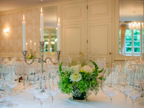 a table with wine glasses and flowers and candles at Romantik Hotel-Restaurant Altenberger Hof in Odenthal