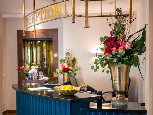 a lobby with a vase of flowers on a table at Romantik Hotel-Restaurant Altenberger Hof in Odenthal