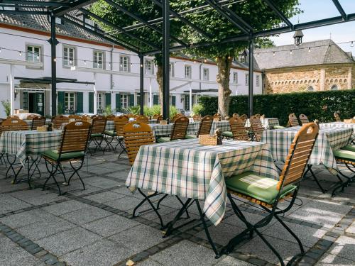 a group of tables and chairs with green and white table cloth at Romantik Hotel-Restaurant Altenberger Hof in Odenthal