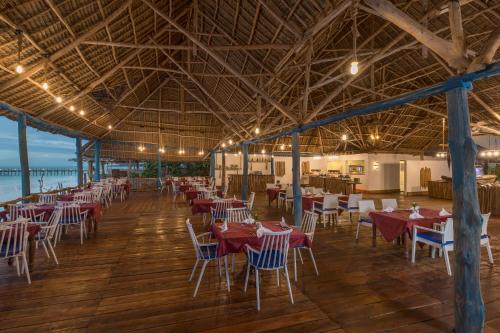 a restaurant with tables and chairs in a building at Kiwengwa Beach Resort in Kiwengwa