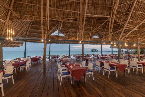 a restaurant with tables and chairs on the beach at Kiwengwa Beach Resort in Kiwengwa