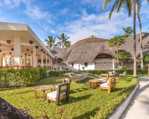 a resort with chairs and tables in the grass at Kiwengwa Beach Resort in Kiwengwa
