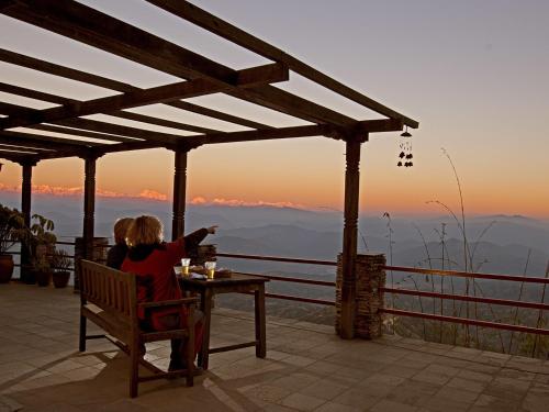 two people sitting at a table watching the sunset at Hotel Country Villa in Nagarkot