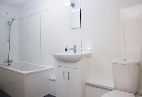 Baño blanco con aseo y lavamanos en Garden House Stamford, en Lincolnshire