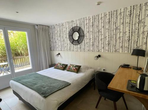 Schlafzimmer mit einem Bett, einem Tisch und einem Schreibtisch in der Unterkunft Le Clos Du Pontic Logis et Cit'Hotel in Landerneau