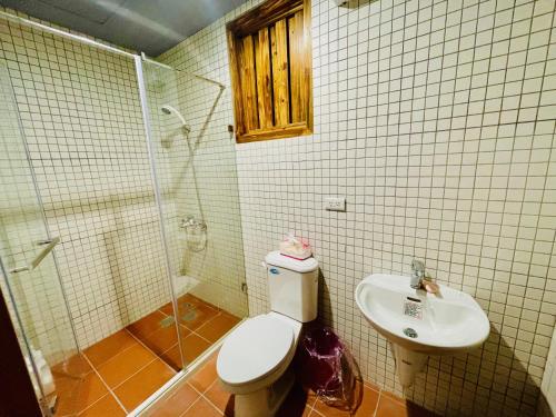 La salle de bains est pourvue de toilettes, d'une douche et d'un lavabo. dans l'établissement Six Hotel, à Jinning