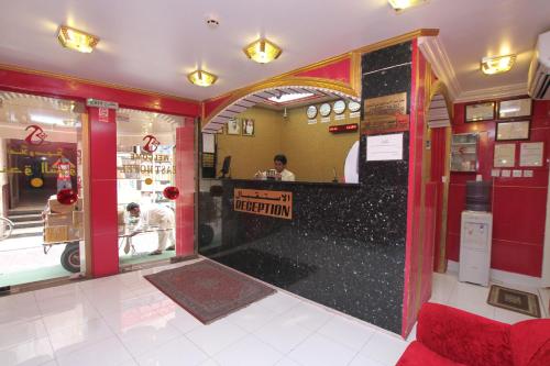 a restaurant with a counter and a person in the kitchen at Zaineast Hotel in Dubai