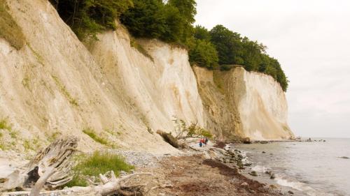 eine Gruppe von Menschen, die am Strand entlang einer Klippe spazieren in der Unterkunft Fewo Krysik Unterdeck in Lühmannsdorf