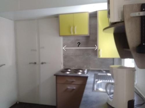 ポール・ラ・ヌーヴェルにあるNovelaの黄色のキャビネット付きのキッチン、ドアが備わります。