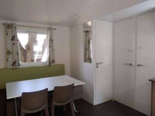 Una habitación con una mesa y sillas y una ventana. en Novela, en Port-la-Nouvelle