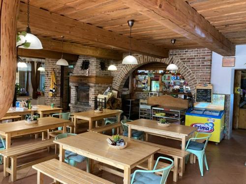 a restaurant with wooden tables and chairs and a fireplace at SKI-BIKE APARTMENTS in Železná Ruda