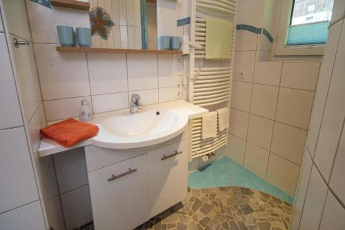 uma casa de banho branca com um lavatório e um chuveiro em Ferienhof Steinmüller em Bad Hindelang