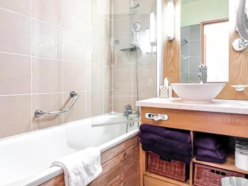 a bathroom with a sink and a bath tub and a sink at Bright, spacious South-facing 1-bedroom apartment in Flaine