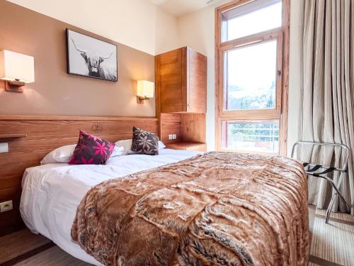 a bedroom with a large bed and a window at Bright, spacious South-facing 1-bedroom apartment in Flaine