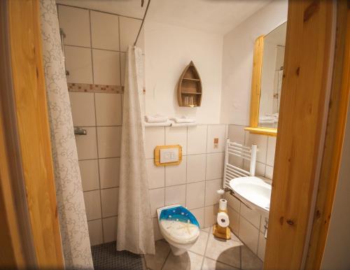 a bathroom with a toilet and a sink and a mirror at Hotel & Restaurant Elbschetal in Wetter