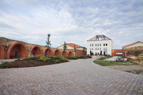 una carretera adoquinada que conduce a un edificio con un edificio blanco en THAYA vinařství en Havraníky