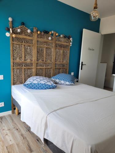 Schlafzimmer mit einem großen Bett mit einem Kopfteil aus Holz in der Unterkunft Gîte Du Soleil Maison lumineuse avec terrasse solarium parking privé in Sorède
