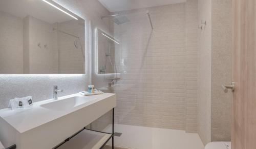 a white bathroom with a sink and a shower at RH Bayren Hotel & Spa 4* Sup in Gandía