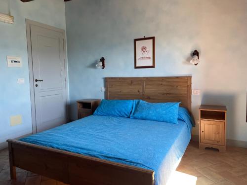 a bedroom with a bed with a blue comforter at Il Borgo Affitacamere in Castiglione in Teverina