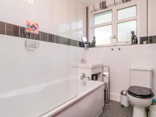 a white bathroom with a tub and a toilet at The Perch in Bexley