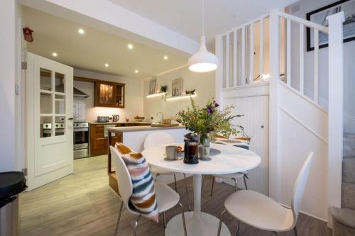 a kitchen and dining room with a white table and chairs at Nutmeg House in Lymington