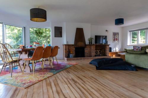a living room with a table and chairs and a fireplace at Furzedown Farm House in Hythe