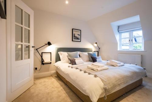 1 dormitorio con 1 cama grande y ventana en Nutmeg House, en Lymington