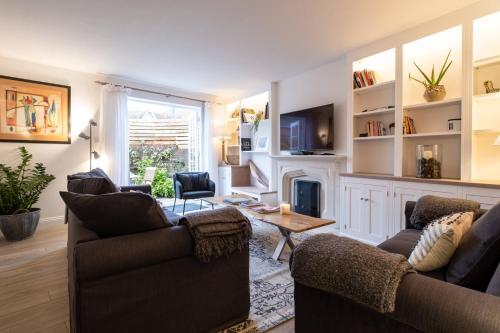 a living room with two couches and a fireplace at Nutmeg House in Lymington
