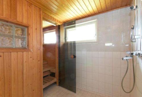 a bathroom with a shower with a glass door at Authentic Wooden House by the River with an Igloo in Rovaniemi