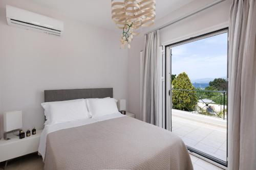 una camera da letto con un letto e una grande finestra di Villa Maria Rose a Kassiopi