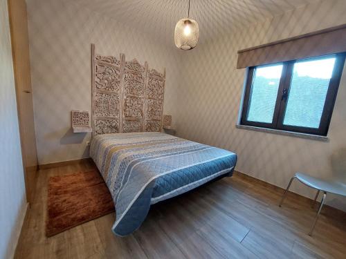 1 dormitorio con cama, ventana y mesa en Casa do Pátio, en Sabugueiro