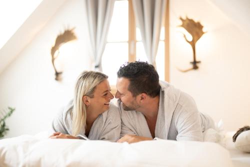 a man and a woman laying on a bed at WIENER Kellerstöckl - Das 11er in Eltendorf