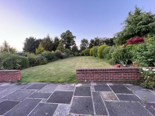 a garden with a brick path and a lawn at Charming 3 bed Bungalow in Bromley
