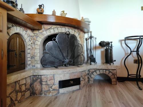 a stone fireplace with a fan on top of it at Anima d'Orcia - Ampio appartamento in pieno centro storico! in San Quirico dʼOrcia