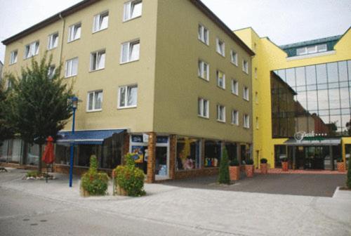 a large yellow building on the side of a street at Hotel Garni in Bad Schallerbach