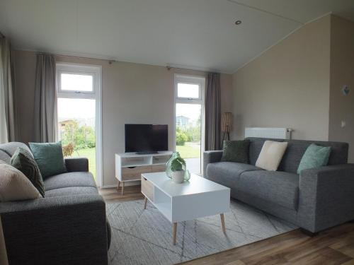 a living room with two couches and a tv at Camping de Vogel in Hengstdijk