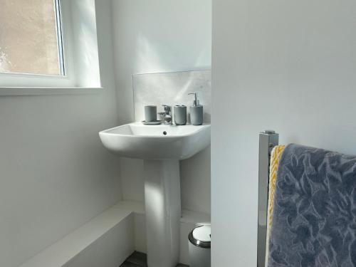 a white bathroom with a sink and a mirror at Stanhope Road in South Shields
