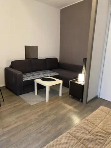 uma sala de estar com um sofá preto e uma mesa em Appartement 4 couchages - Port ciotat em La Ciotat