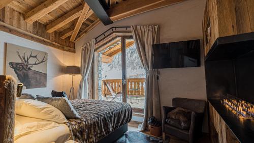 - une chambre avec un lit, une cheminée et une télévision dans l'établissement Chalet Orca, Val d'Isère - 14 pers - 420m2, à Val dʼIsère