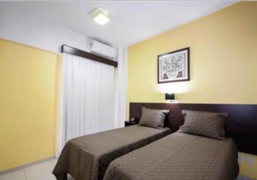 um quarto de hotel com duas camas e uma janela em Flat em Frente a USP - Centrinho - CPO - Medicina em Bauru