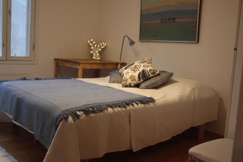 a bedroom with a bed with a lamp and a table at Authentic Wooden House by the River with an Igloo in Rovaniemi