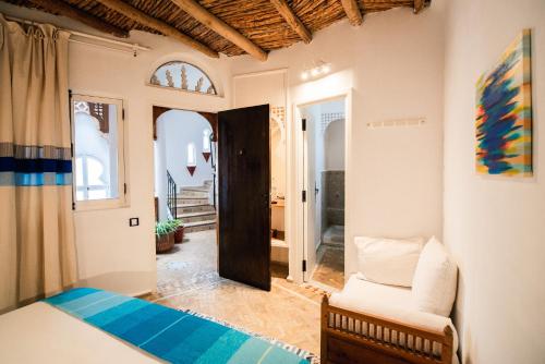 um quarto com uma cama, um sofá e uma cadeira em Dar Liouba Hotel em Essaouira