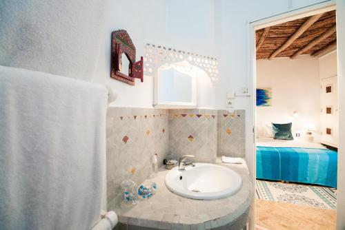 baño con lavabo y cama en Dar Liouba Hotel, en Essaouira