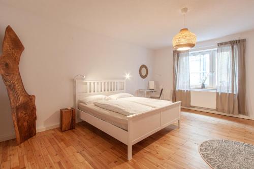 a bedroom with a white bed and a window at Wohnen an der Residenz mit Terrasse bis zu 8 Personen in Würzburg