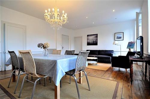 une table à manger avec des chaises et un salon dans l'établissement Saint Malo Solidor vue mer BRECEL 1, à Saint-Malo