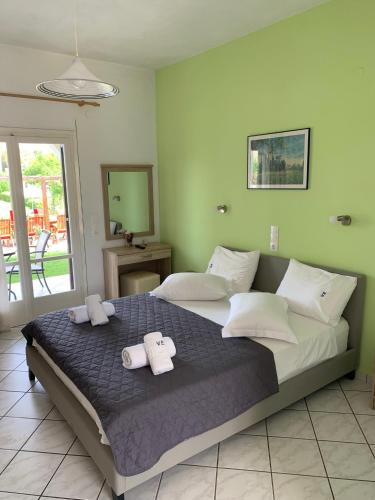 a bedroom with a large bed with towels on it at Eleftheria Studios and Apartments in Acharavi