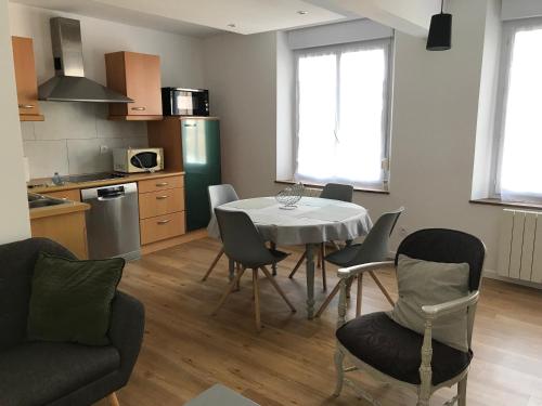 une cuisine et une salle à manger avec une table et des chaises dans l'établissement Le saint Pierre, à Roye