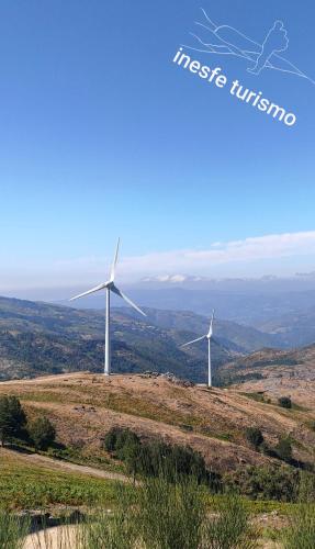 two wind turbines on top of a hill at Miradouro da Branda in Branda de Santo António