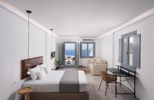 El Destino Suites في أكروتيري: غرفة نوم مع سرير وغرفة معيشة